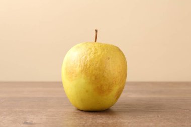 Ahşap masada çürük yeşil bir elma