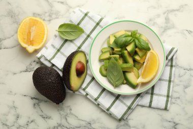 Lezzetli yeşil avokadolar, fesleğen ve limon beyaz mermer masa, düz yatıyordu.