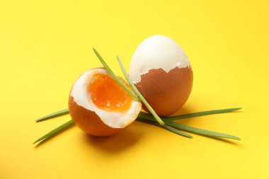 Sarı arka planda yeşil soğanlı rafadan yumurta, yakın plan.