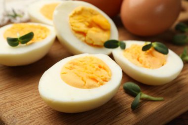 Tahta masanın üzerinde mikro yeşillikli haşlanmış yumurtalar, yakın plan.