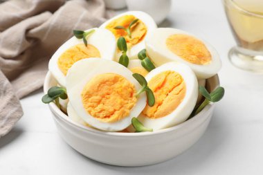 Beyaz masadaki mikro yeşilliklerle haşlanmış yumurtalar, yakın plan.