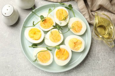 Haşlanmış yumurta ve mikroyeşiller gri masada, düz yerde.