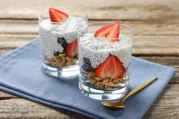 Chia tohumlu lezzetli tatlı, yoğurt, granola, çilek ve böğürtlen ahşap masada, yakın plan. Süper yemek.