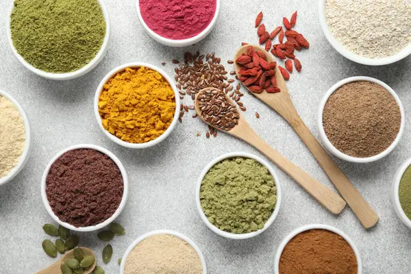 Açık gri masada farklı süper yiyecek tozları, düz yatıyordu.