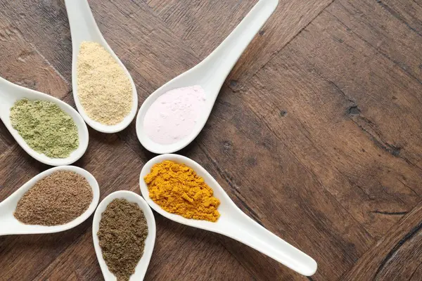 Tahta masadaki kaşıklardaki farklı süper yiyecek tozları. Metin için boşluk