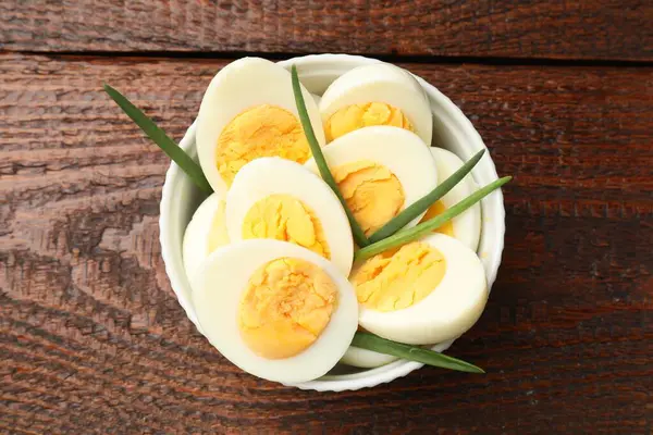 Haşlanmış yumurta ve yeşil soğan ahşap masada, üst manzara.