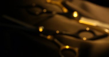 Siyah kumaş üzerinde makas, yakın plan. Işığın yönü değiştiriliyor