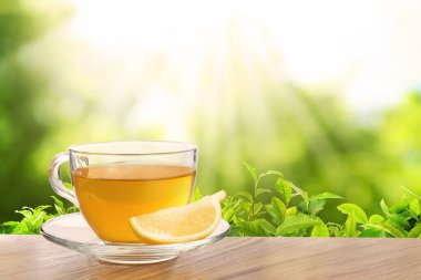 Çay çiftliğindeki ahşap masada yeşil çay ve limon dilimi. Metin için boşluk