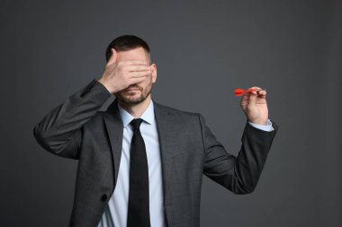 Hedef alınıyor. Gri arka planda dart gözü olan bir adam.