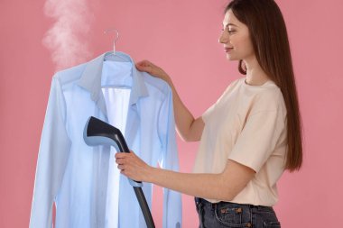 Pembe arka planda dumanı üstünde güzel bir kadın.