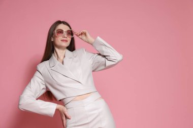 Pembe arka planda şık giyinmiş güzel bir kadının moda portresi. Metin için boşluk