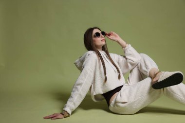 Yeşil arka planda şık giyinmiş güzel bir kadının moda portresi.