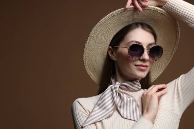 Kahverengi arka planda şık giyinmiş güzel bir kadının moda portresi. Metin için boşluk