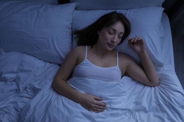 Evdeki yatakta uyuyan güzel bir kadın.