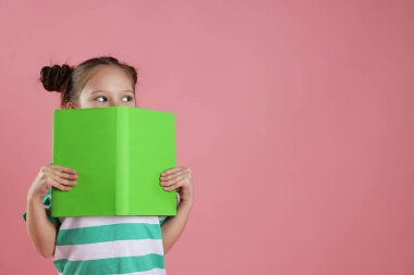 Pembe arka plan kitabı olan hoş bir kız, mesaj için boş yer.