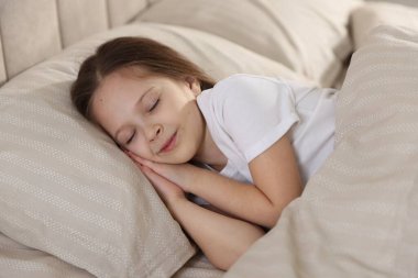 Evde yatakta uyuyan tatlı bir kız.