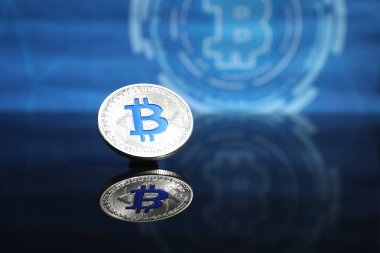 Kripto para birimi. Ayna yüzeyinde bir bitcoin, yakın plan. Metin için boşluk