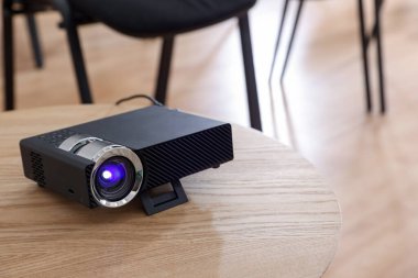 Modern video projektörü konferans odasındaki masada.