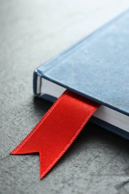 Gri desenli masa üzerinde kırmızı kurdele yer imi olan planlayıcı, yakın plan