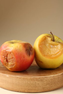 Bej arka planda iki çürük elma, yakın plan.