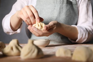 Mutfaktaki masada khinkali yapan kadın, yakın plan.