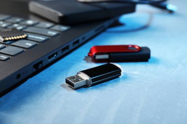 Mavi desenli tablo üzerinde Usb flash diskleri ve dizüstü bilgisayarı, yakın plan
