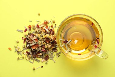 Cam fincanda nefis bitki çayı ve yeşil arka planda kuru yapraklar.