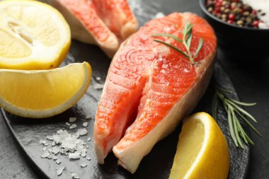 Deniz ürünleri. Somon bifteği, baharat ve limon masada, yakın plan.