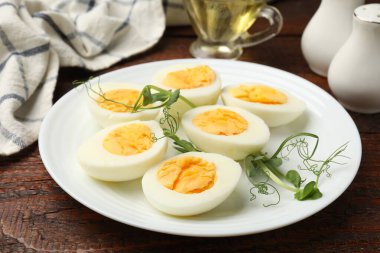 Haşlanmış yumurta ve mikroyeşiller ahşap masada, yakın plan.