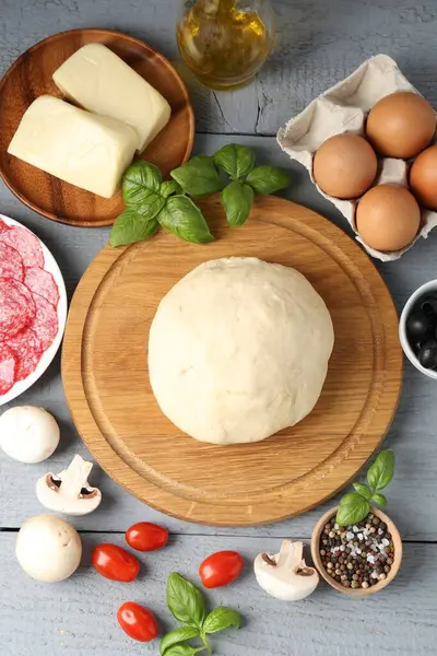 Pizza yapıyorum. Gri ahşap masadaki farklı malzemeler.