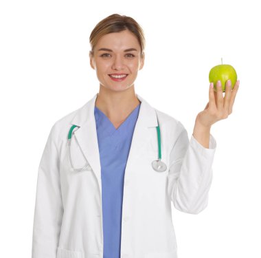 Beyaz arka planda yeşil elmalı ve steteskoplu beslenme uzmanı.