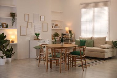 Odada rahat bir kanepe ve sandalyeli şık bir yemek masası. İç tasarım