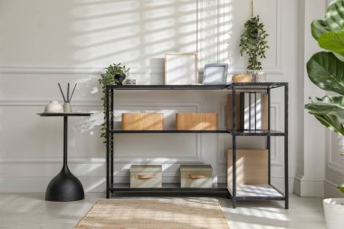 Beyaz duvarın yanında farklı dekorları olan konsol masası. İç tasarım