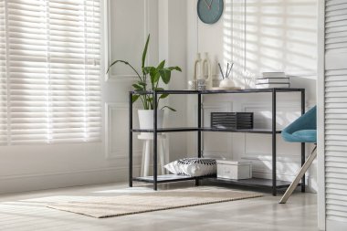 Beyaz duvarın yanında farklı dekorları olan konsol masası. İç tasarım