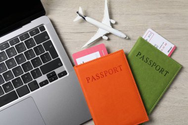 Pasaportlar, uçuş biletleri, uçak modeli ve dizüstü bilgisayar ahşap masada, düz konum