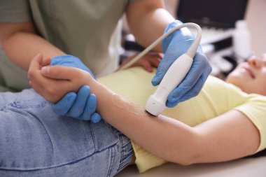 Sonograf, klinikte kızın kolunun ultrason muayenesi yapıyor.