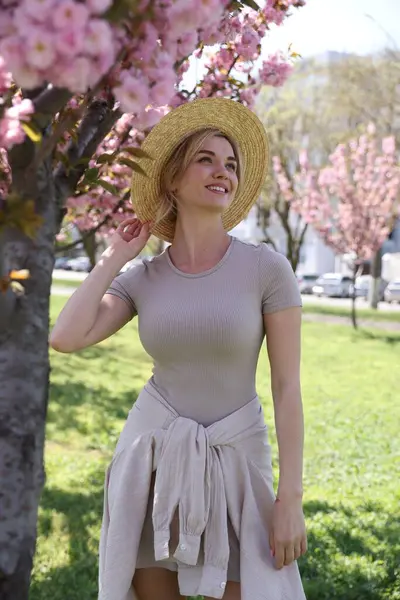 Parkta çiçek açan ağaçların yanında güzel bir kadının portresi