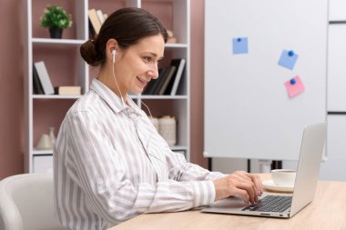 Gülümseyen çevrimiçi hoparlör masadaki dizüstü bilgisayarla internetten yayın yapıyor.