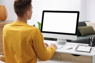 Ofisteki beyaz masada bilgisayarda çalışan bir adam. Tasarım için model