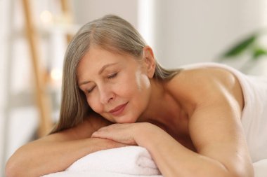 Son sınıf öğrencisi masaj salonundaki kanepede dinleniyor.