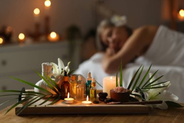 Üst düzey kadın masaj koltuğunda dinleniyor, farklı spa ürünlerine odaklanıyor.