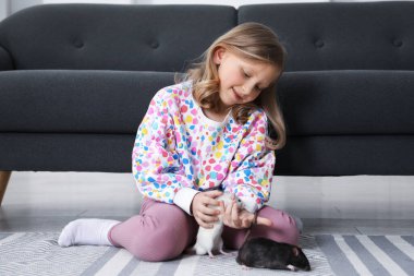 Evinde yerde sevimli fareleri olan küçük kız.