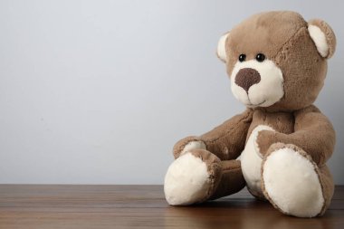 Küçük arka planda tahta masada sevimli bir oyuncak ayı. Metin için boşluk