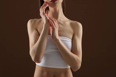 Kahverengi arka planda mükemmel bir cildi olan kadın, yakın plan.