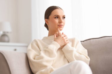 Evdeki kanepede güzel bir genç kadının portresi.