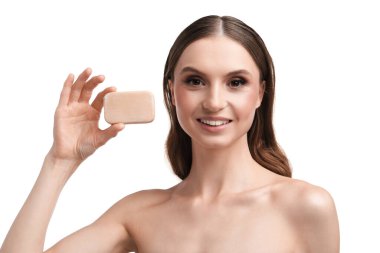 Beyaz arka planda sabun çubuğuyla gülümseyen kadın, yakın plan.