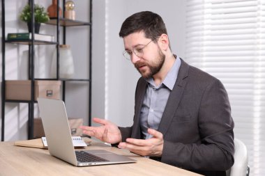 İçerideki masada dizüstü bilgisayarı olan internet hoparlörü.