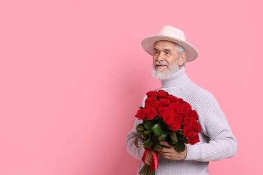 Pembe arka planda kırmızı gül buketi olan son sınıf öğrencisi, mesaj için yer var.