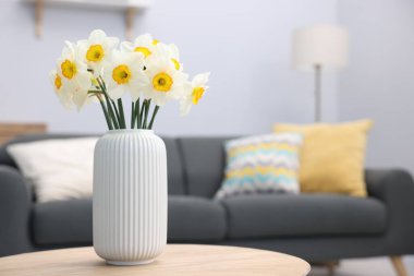 İçerideki ahşap masada vazodaki güzel nergisler, metin için yer.