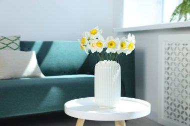 İçerideki masada vazodaki güzel nergisler.